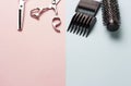 Scissors and comb on a pink and blue background, copy space Royalty Free Stock Photo