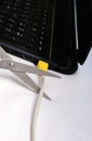 Scissors cut the cable connected to a laptop Royalty Free Stock Photo