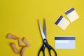 Scissors cut credit card on a green background with crumpled paper and breadcrumbs on a yellow background flat lay Royalty Free Stock Photo