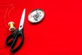 Scissors for cutting, needles and thread on a red cloth. Concept design clothes Royalty Free Stock Photo