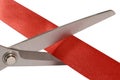 Scissors cutting red ribbon or tape, close up