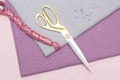 Scissors and a measuring tape lie on the caresses of the fabric. sewing hobby concept. Royalty Free Stock Photo