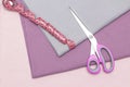 Scissors and a measuring tape lie on the caresses of the fabric. sewing hobby concept. Royalty Free Stock Photo