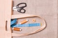 scissors, measuring tape and several spools of thread in an eco bag on linen fabric Royalty Free Stock Photo