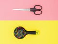 Scissors and multi-colored comb on a background of two colors. The view from the top. Flat lay. Royalty Free Stock Photo