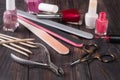 Scissors, nail files and clippers manicure with polish bottles on a dark wooden background Royalty Free Stock Photo