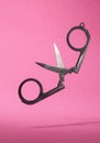 Scissors opened isolated in pink background