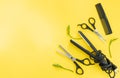 Scissors and other hairdresser's accessories on yellow background, flat lay. Space for text Royalty Free Stock Photo