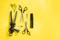 Scissors and other hairdresser's accessories on yellow background, flat lay. Space for text Royalty Free Stock Photo