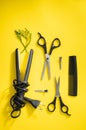 Scissors and other hairdresser's accessories on yellow background, flat lay. Space for text Royalty Free Stock Photo