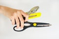 Scissors, pliers and a knife for cutting paper in hand. Construction tools on white background
