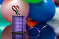 Scissors and purple washi tape at blurred multicolored balloons. copy space. selective focus. handiwork and art creativity. for de