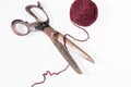 Scissors and a red ball of woolen thread isolated Royalty Free Stock Photo