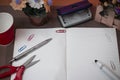 Scissors and stationary with checkered math book above textured backdrop. Writing equipment on an unplain floor