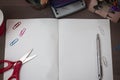 Scissors and stationary with checkered math book above textured backdrop. Writing equipment on an unplain floor