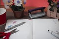 Scissors and stationary with checkered math book above textured backdrop. Writing equipment on an unplain floor