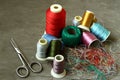 Scissors, tangled colored threads and spools of thread are on the concrete Royalty Free Stock Photo