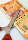 Scissors try to cut Indian two hundred rupees note on a white background. Split money, financial share, devaluation of currency, Royalty Free Stock Photo