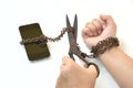 Scissors trying to cut rusty iron chain that ties together hand and smart phone Royalty Free Stock Photo