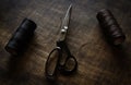 Scissors and waxed threads on a brown table.