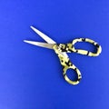 Scissors with a yellow  handle on a blue background. Royalty Free Stock Photo