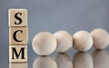 SCM - acronym on wooden cubes on the background of light balls Royalty Free Stock Photo