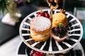 Scone Pie topping with icing and Blueberry Mini Tart on black and white plate. Dessert for afternoon tea