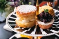 Scone Pie topping with icing and Blueberry Mini Tart on black and white plate. Dessert for afternoon tea