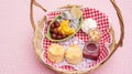 Scone, strawberry jam, almond, and mixed fruit in a basket