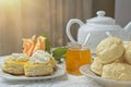 Scones with apricot jam and whipped cream on a table with jar of jam