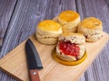 Scones traditional English delicious freshly baked homemade with strawberry jam on a wooden cutting board Royalty Free Stock Photo