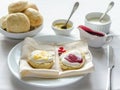 Scones with whipped cream, lemon curd and cranberry jam