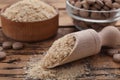 Scoop of brewer`s yeast flakes on wooden table, closeup. Space for text