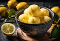 A scoop of bright yellow lemon sorbet in a cup.