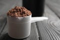 Scoop of chocolate protein powder on wooden table Royalty Free Stock Photo