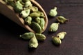 Scoop with dry cardamom pods on wooden table, closeup Royalty Free Stock Photo
