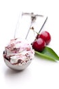 A scoop of fruit ice cream with fresh cherries