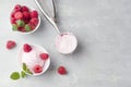 A scoop of homemade raspberry ice cream with fresh raspberries and mint in a white cup on a light background. Delicious and Royalty Free Stock Photo