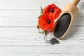Scoop of poppy seeds and flowers on white wooden table, flat lay Royalty Free Stock Photo