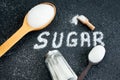 Scoop with powdered white sugar on a black background. Sugar Inscription on a dark background