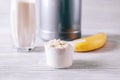 Scoop with protein powder, banana and glass