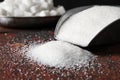 Scoop with refined sugar on table, closeup