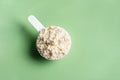 Scoop of whey protein powder on green Royalty Free Stock Photo