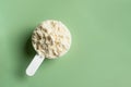 Scoop of whey protein powder on green Royalty Free Stock Photo