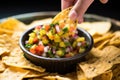 scooping up a grilled pineapple salsa using a crisp tortilla chip Royalty Free Stock Photo