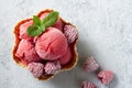 Scoops of delicious refreshing raspberry ice cream decorated with frozen raspberries and mint leaf, served in waffle bowl Royalty Free Stock Photo