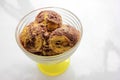 Scoops of orange and chocolate ice cream in a glass dessert bowl on white background with copy space. Selective focus