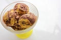 Scoops of orange and chocolate ice cream in a glass dessert bowl on white background with copy space. Selective focus