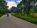 Scooter middle yellow lane street road asphalt trees green grass field agriculture hill mountain reservoir chiang mai