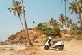 Scooter parked under the palm trees of a beautiful beach in Goa, India Royalty Free Stock Photo